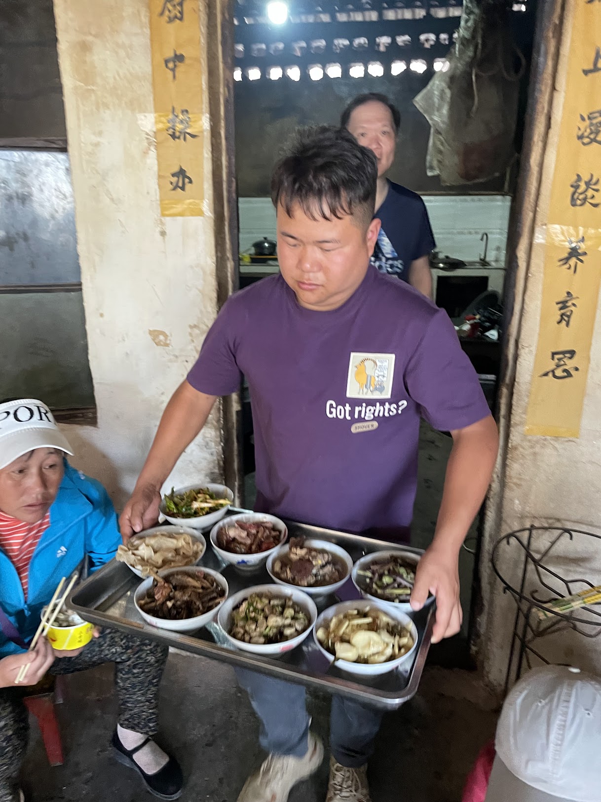 一位男子端着滿盤菜餚上席
